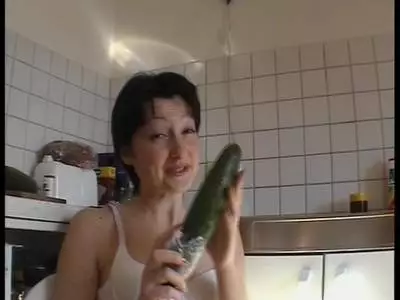 Brünette Frau fickt sich mit großer Salatgurke